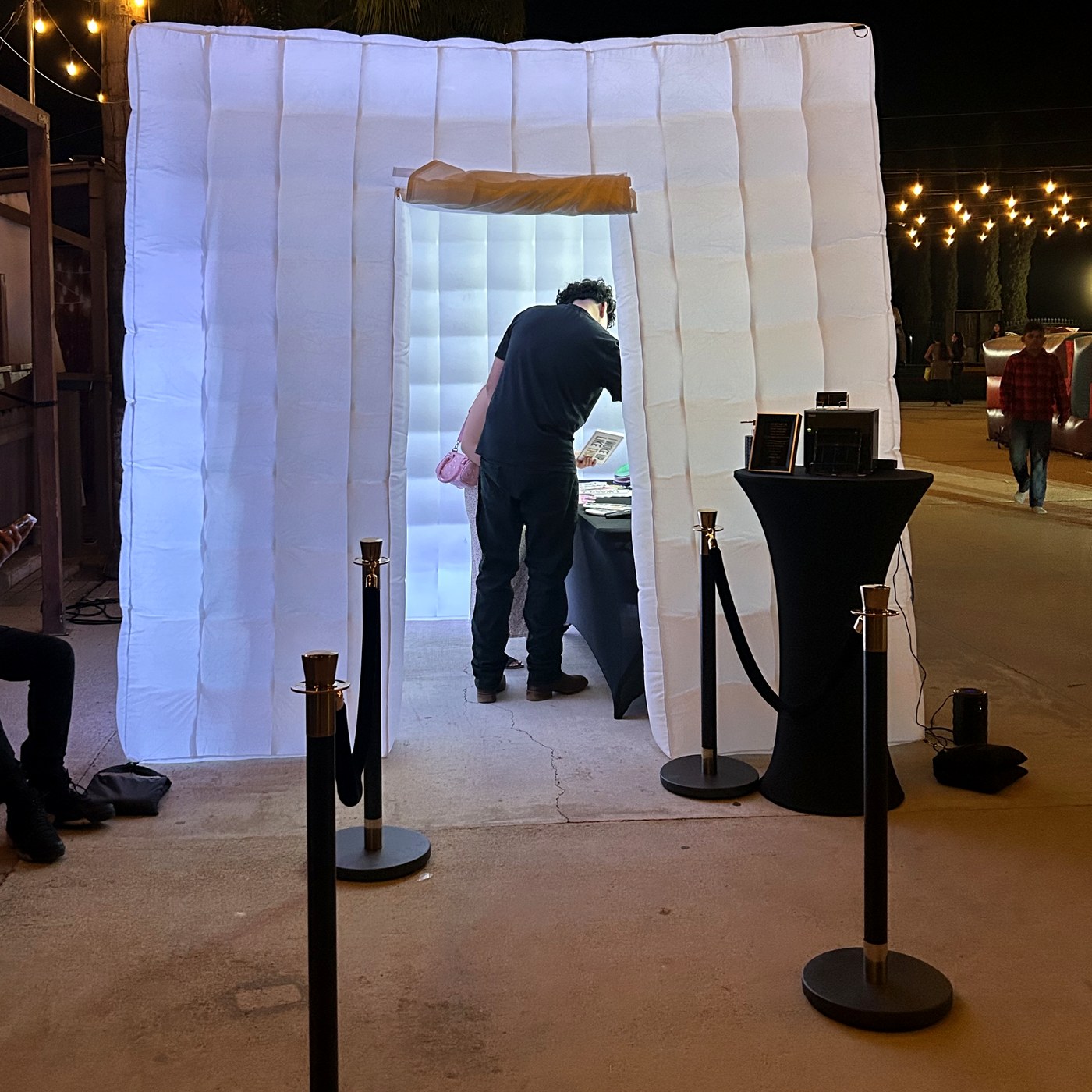 White inflatable photo booth setup at night with event lighting