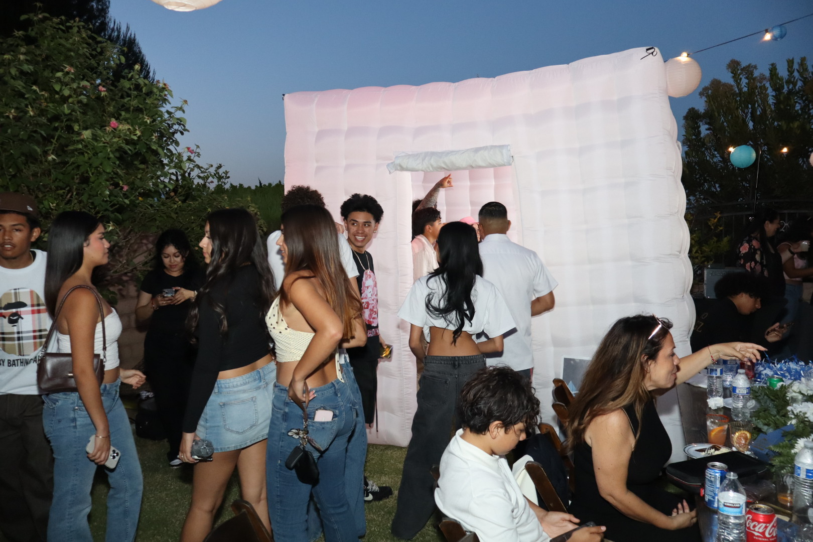 Jaiden's Grad Party guests gathered around the white inflatable booth at dusk by Studio RDRGZ LA
